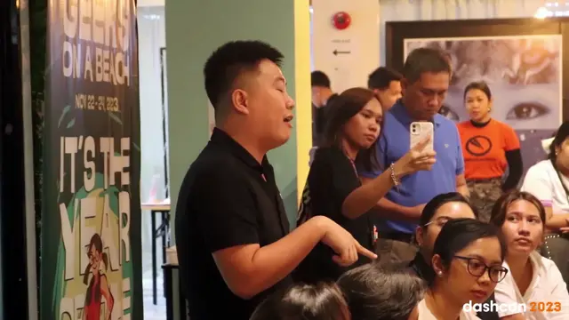 DashCon 2023 Cebu speaker talking to a crowd while attendees film on their phones